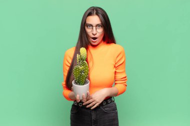 Genç ve güzel bir kadın şok olmuş ya da şaşırmış görünüyor, ağzı açık bir şekilde 