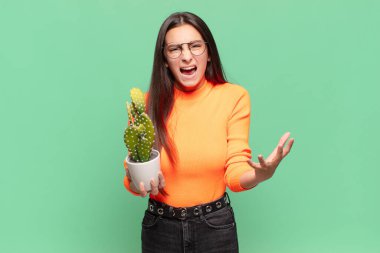 Genç ve güzel bir kadın sinirli, sinirli ve hayal kırıklığına uğramış görünüyor. Ya da senin neyin var? Kaktüs kavramı