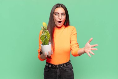 Genç ve güzel bir kadın ağzı açık ve şaşırmış, şok olmuş ve hayrete düşmüş inanılmaz bir sürprizle. Kaktüs kavramı