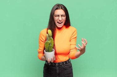 Genç ve güzel bir kadın umutsuz ve hayal kırıklığına uğramış görünüyor, stresli, mutsuz ve sinirli, bağırıyor ve çığlık atıyor. Kaktüs kavramı