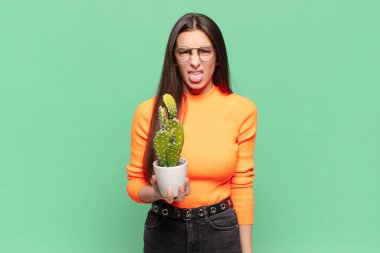 Genç ve güzel bir kadın iğrenmiş ve rahatsız olmuş hissediyor. Dilini dışarı çıkarıyor. Çirkin ve iğrenç şeylerden hoşlanmıyor. Kaktüs kavramı