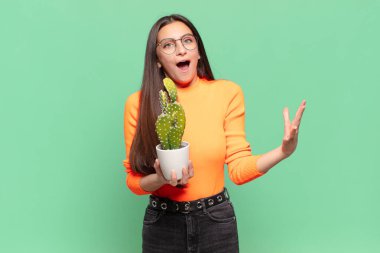 Genç ve güzel bir kadın şok olmuş ve şaşırmış, endişeli ve paniklemiş hissediyor, stresli ve dehşete kapılmış bir bakışla. Kaktüs kavramı