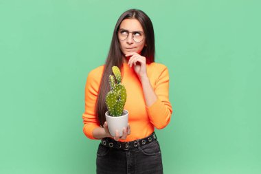 Genç, güzel bir kadın düşünüyor, kuşkulu ve şaşkın hissediyor, farklı seçeneklerle, hangi kararı vereceğini merak ediyor. Kaktüs kavramı