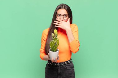 Şok olmuş, şaşırmış bir ifadeyle ağzı kapalı genç ve güzel bir kadın sır saklıyor ya da 