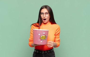 Genç ve güzel bir kadın şok olmuş ya da şaşırmış görünüyor, ağzı açık bir şekilde 