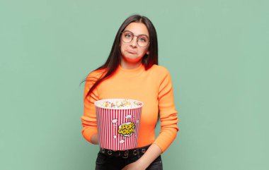 Genç, güzel bir kadın üzgün ve mızmızlanıyor. Mutsuz bir bakışı var. Olumsuz ve hayal kırıklığına uğramış bir tavırla ağlıyor. patlamış mısır konsepti