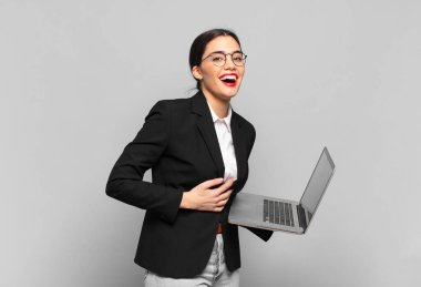 Genç ve güzel bir kadın kameraya bakıyor. Tatmin olmuş, kendinden emin, dostane bir gülümsemeyle. Seni seçiyor. dizüstü bilgisayar