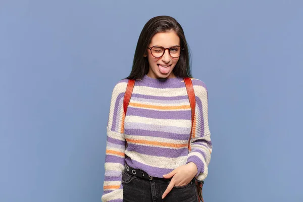 陽気で屈託のない反抗的な態度で冗談を言って舌を突き出す若い可愛い女性 学生のコンセプト — ストック写真