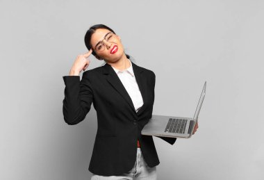 Genç, güzel bir kadın kafası karışık ve şaşkın hissediyor. Deli, deli ya da aklını kaçırmış olduğunu gösteriyor. dizüstü bilgisayar