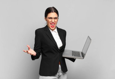 Genç, güzel bir kadın kızgın, sinirli ve sinirli görünüyor. Senin neyin var? dizüstü bilgisayar 