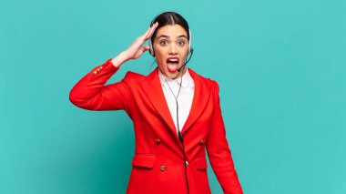 Genç, güzel bir kadın mutlu, şaşkın ve şaşırmış görünüyor, gülümsüyor ve inanılmaz ve inanılmaz iyi haberleri fark ediyor. tele pazarlamacı kavramı