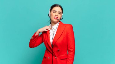 Genç, güzel bir kadın stresli, endişeli, yorgun ve hayal kırıklığına uğramış, gömleğini çekmiş, sorunlu görünüyor. tele pazarlamacı kavramı