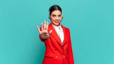 Genç ve güzel bir bayan gülümsüyor ve arkadaş canlısı görünüyor. Beş ya da beş numarayı gösteriyor. Elleri önde ve geri sayıyor. tele pazarlamacı kavramı