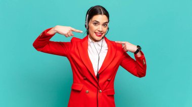 Genç, güzel bir kadın, kendine güvenerek gülümsüyor. Geniş bir gülümseme, pozitif, rahat, tatmin olmuş bir tavır sergiliyor. tele pazarlamacı kavramı