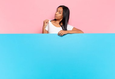 Genç siyahi kadın kibirli, başarılı, pozitif ve gururlu görünüyor, kendini işaret ediyor. boşluk konseptini kopyala