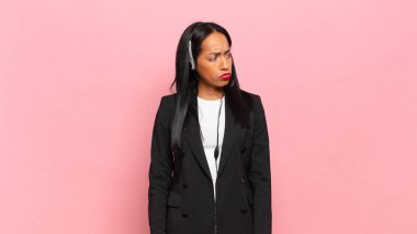 Genç siyahi kadın üzgün, üzgün ya da kızgın hissediyordu ve olumsuz bir tavır sergiliyordu, anlaşmazlık içinde kaşlarını çatıyordu. tele pazarlama kavramı