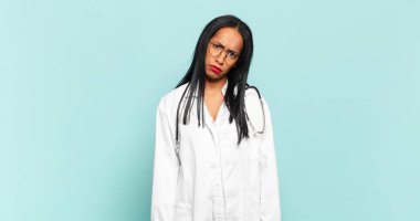 young black woman feeling puzzled and confused, with a dumb, stunned expression looking at something unexpected. physician concept