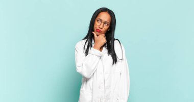 Genç siyahi kadın düşünüyor, kuşkulu ve şaşkın hissediyor, farklı seçeneklerle, hangi kararı vereceğini merak ediyor. hekimlik kavramı