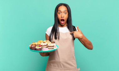 Genç siyahi kadın mutlu, şaşkın ve gururlu hissediyordu. Heyecanlı ve şaşkın bir bakışla kendini gösteriyordu. Fırın şefi konsepti