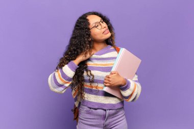 Genç İspanyol kadın stresli, endişeli, yorgun ve hayal kırıklığına uğramış, gömleğini çekmiş, sorunlu görünüyor. öğrenci konsepti