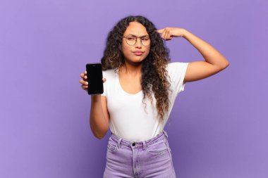 Genç İspanyol kadın şaşkın ve şaşkın hissediyor. Deli, deli ya da aklını kaçırmış olduğunu gösteriyor. akıllı telefon kavramı