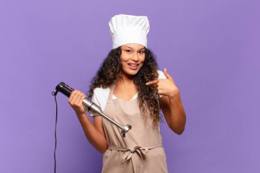 Genç İspanyol kadın mutlu, şaşkın ve gururlu hissediyor. Heyecanlı ve şaşkın bakışlarıyla kendini işaret ediyor. Şef konsepti