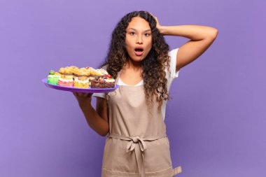 Genç İspanyol kadın kendini stresli, endişeli, endişeli ya da korkmuş hissediyordu. Elleri başının üstünde, hatayla panikliyordu. kek pişirme kavramı