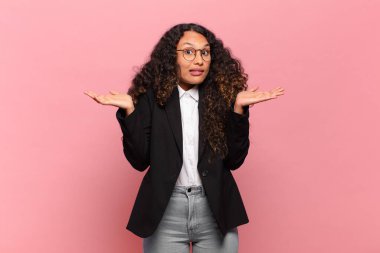 Genç İspanyol kadın şaşkın ve şaşkın hissediyor, şüpheci, farklı seçenekleri tartıyor ya da komik bir ifadeyle seçiyor. iş kavramı