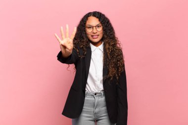 Genç İspanyol kadın gülümsüyor ve arkadaş canlısı görünüyor. Dört ya da dört numarayı gösteriyor. Elleri önde, geriye doğru sayıyor. iş kavramı