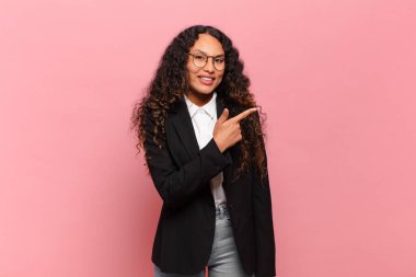 Genç İspanyol kadın heyecanlı ve şaşırmış görünüyor. Kenarlarını ve yukarıyı göstererek mekanı kopyalıyor. iş kavramı