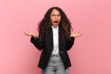 Genç İspanyol kadın ağzı açık ve şaşırmış, şok olmuş ve inanılmaz bir sürprizle şaşkına dönmüş. iş kavramı