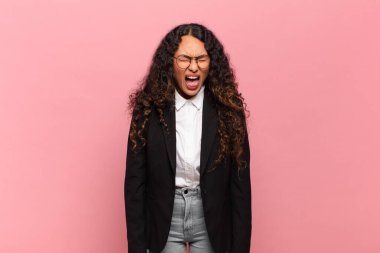 Genç İspanyol kadın agresif bir şekilde bağırıyor, çok kızgın, hayal kırıklığına uğramış, öfkeli ya da sinirli görünüyor, hayır diye bağırıyor. iş kavramı