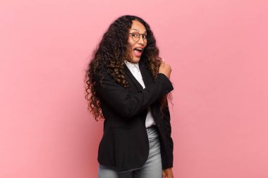 Genç İspanyol kadın mutlu, pozitif ve başarılı hissediyor, bir meydan okumayla karşılaştığında ya da iyi sonuçları kutladığında motive oluyor. iş kavramı