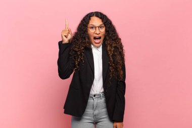 Genç İspanyol kadın bir fikri fark ettikten sonra mutlu ve heyecanlı bir dahi gibi hissediyor, neşeli bir şekilde parmağını kaldırıyor, eureka! iş kavramı