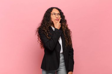 Genç İspanyol kadın düşünüyor, kuşkulu ve şaşkın hissediyor, farklı seçeneklerle, hangi kararı vereceğini merak ediyor. iş kavramı