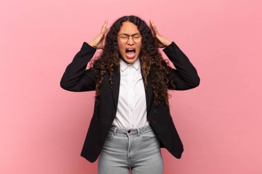 Genç İspanyol kadın elleri havada bağırıyor, öfkeli, sinirli, stresli ve üzgün hissediyor. iş kavramı