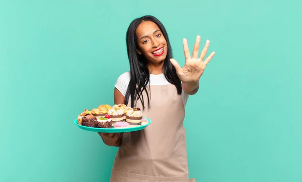 若い黒人女性は笑顔で友好的に見える前方に手で5番目か5番目を示しカウントダウン パン屋のコンセプト — ストック写真