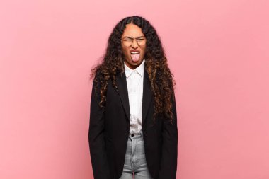 Genç İspanyol kadın tiksinmiş ve rahatsız olmuş hissediyor. Dilini dışarı çıkarıyor. Çirkin ve iğrenç bir şeyden hoşlanmıyor. iş kavramı