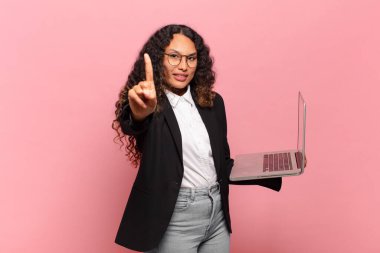 Genç İspanyol kadın gülümsüyor ve arkadaş canlısı görünüyor, bir numara ya da ilk eli önde, geriye doğru sayıyor. dizüstü bilgisayar