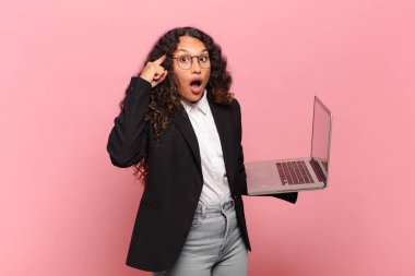 Genç İspanyol kadın şaşırmış, ağzı açık, şok olmuş, yeni bir düşünce, fikir ya da konsept keşfediyor. dizüstü bilgisayar