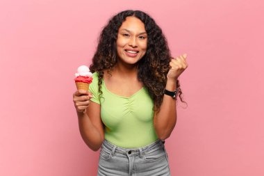 Genç İspanyol kadın şok olmuş, heyecanlı ve mutlu hissediyor, gülüyor ve başarıyı kutluyor, vay canına! dondurma konsepti