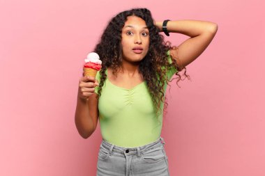 Genç İspanyol kadın kendini stresli, endişeli, endişeli ya da korkmuş hissediyordu. Elleri başının üstünde, hatayla panikliyordu. dondurma konsepti