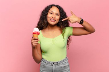 Genç İspanyol kadın kendine güvenerek gülümsüyor. Geniş gülümseme, pozitif, rahat, tatmin olmuş tavır. dondurma konsepti