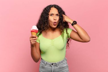 Genç İspanyol kadın şaşırmış, ağzı açık, şok olmuş, yeni bir düşünce, fikir ya da konsept keşfediyor. dondurma konsepti