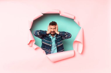 Genç, deli, sakallı adam. kağıt deliği boş arkaplan kavramı