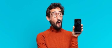 Genç, deli, sakallı adam. Şaşırmış ya da şok olmuş. akıllı telefon kavramı