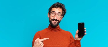 Genç, deli, sakallı adam. İşaret işareti. akıllı telefon kavramı