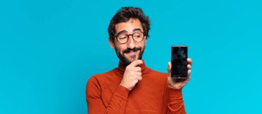 Genç, deli, sakallı adam. Düşünen ya da şüphe eden bir ifade. akıllı telefon kavramı