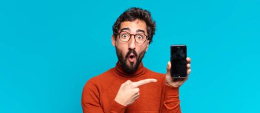Genç, deli, sakallı adam. Şaşırmış ya da şok olmuş. akıllı telefon kavramı