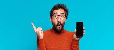 Genç, deli, sakallı adam. Şaşırmış ya da şok olmuş. akıllı telefon kavramı